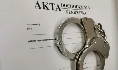 Metalowe kajdanki leżą na tle formularza śledczego z napisem „AKTA DOCHODZENIA ŚLEDZTWA”.